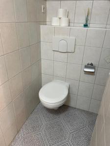 ein Bad mit WC in einem gefliesten Zimmer in der Unterkunft Hummelglück - Ferienwohnung mit Terrasse in 30 Min in HH City in Bendestorf