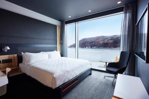 セントジョンズにあるAlt Hotel St. John'sのベッドと大きな窓があるホテルの部屋