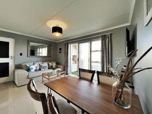 Cape Town的住宿－Big Bay Beach Front Estate Apartment，客厅配有桌子和沙发