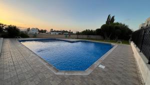 a swimming pool with blue water in a backyard at Sea-View Eco-Apartment B110 in Polis Chrysochous