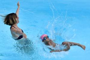 zwei Leute spielen in einem Schwimmbad in der Unterkunft Villa La Couaste in Lorgues