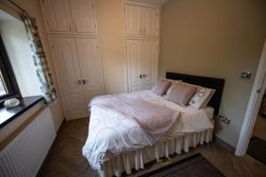 a bedroom with a bed with white sheets and pillows at The Larches in Bewdley