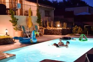 zwei Personen in einem Schwimmbad in der Nacht in der Unterkunft Villa La Couaste in Lorgues