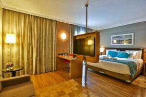a hotel room with a bed and a television at Quality Hotel & Suites Brasília in Brasília