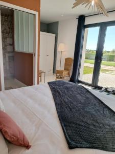 ein Schlafzimmer mit einem großen Bett und einem großen Fenster in der Unterkunft Maison Bailly in Ducey