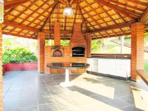 - un pavillon avec une table et un four en briques dans l'établissement Lindo Sitio na beira da represa em Santa Isabel - SP, à Igaratá