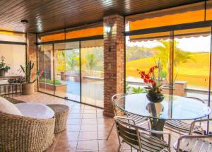 une salle à manger avec une table et des chaises sur une terrasse dans l'établissement Lindo Sitio na beira da represa em Santa Isabel - SP, à Igaratá