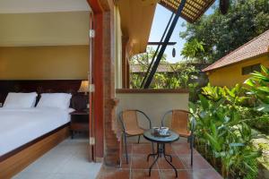 a bedroom with a bed and a table and chairs at Mahe Garden Inn and Villas by Kamara in Kuta +33 photos