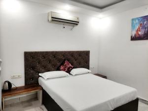 a bedroom with a large white bed with a headboard at Shanti Residency in New Delhi