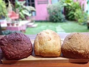three loaves of bread sitting on a cutting board at Pousada Lira Praieira Paraty in Paraty