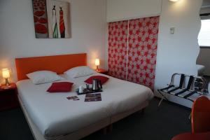 a bedroom with a large bed with red accents at The Originals City, Hôtel Anaïade, Saint-Nazaire Pornichet in Saint-Nazaire