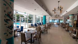 uma sala de jantar com mesas, cadeiras e janelas em Lake Life Hotel em İznik