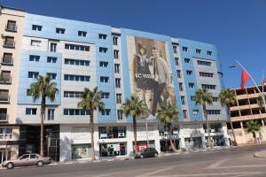 un edificio con un gran anuncio a su lado en Marchica Apartment Nador Jadid Wifi Klima, en Nador