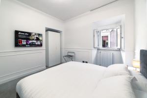 a white bedroom with a bed and a tv at iRoome in Rome