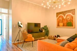 ein Wohnzimmer mit orangefarbenen Möbeln und einem TV in der Unterkunft Villa Santa Madalena, a Home in Madeira in Arco da Calheta