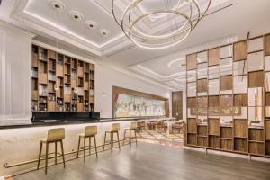 a lobby with a bar with chairs and a chandelier at Fiesta Americana Merida in Mérida +141 photos