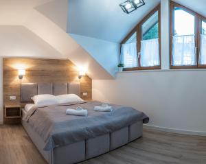 een slaapkamer met een groot bed en 2 handdoeken bij Apartamenty Aspen in Karpacz