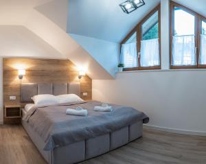 a bedroom with a large bed with two towels on it at Apartamenty Aspen in Karpacz