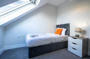 1 dormitorio con cama y ventana en Three bed apartment sleeps 5 in botanic, en Belfast