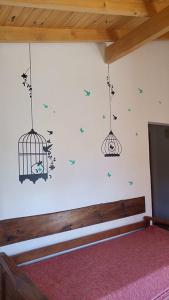 una habitación con una pared con aves y una jaula en Cabañas Las Nanys en Balneario Claromecó