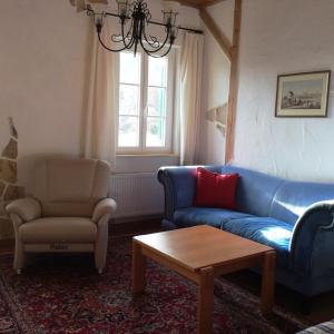 a living room with a blue couch and a chair at Ferienwohnung Rosenlehner in Kiefersfelden