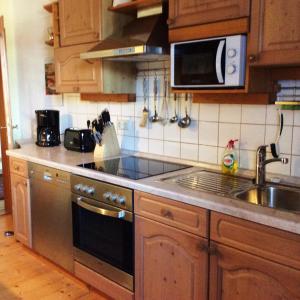 a kitchen with a sink and a stove top oven at Ferienwohnung Rosenlehner in Kiefersfelden