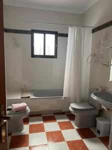 uma casa de banho com uma banheira, um WC e um lavatório. em Villa Gení em La Victoria