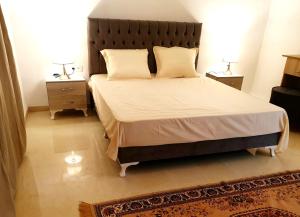 Maison plain-pied avec piscine chauffée في تونس: غرفة نوم بسرير كبير مع مواقف ليلتين