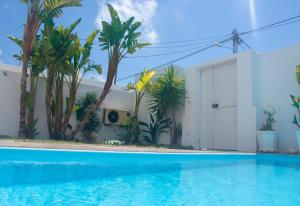 uma piscina em frente a uma casa com árvores em Maison plain-pied avec piscine chauffée em Tunes