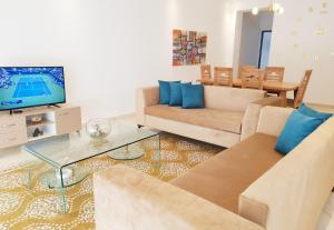 a living room with a couch and a tv at Maison plain-pied avec piscine chauffée in Tunis