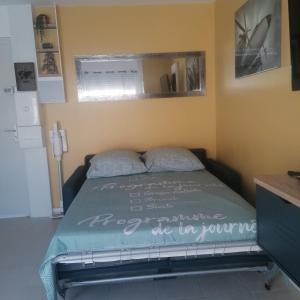- une chambre avec un lit muni d'un panneau dans l'établissement Cosy studio au bord de la plage, à Gruissan
