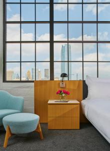 a bedroom with a bed and a table and a chair at Fordson Hotel, in the Unbound Collection by Hyatt in Oklahoma City