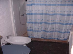 a bathroom with a toilet and a shower curtain at Casas Miraverde in Piriápolis