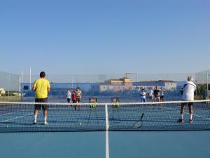 a group of people playing tennis on a tennis court at Marinagri Greenblu Hotel in Policoro