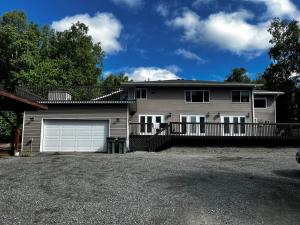 uma casa com garagem e cerca em Newly Remodeled spacious units, minutes from mountains, inlet, downtown and airport em Anchorage