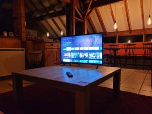 TV en una mesa de madera en una habitación en Chalet Chalon, en Meillerie