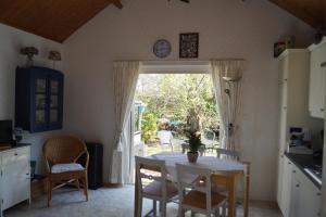 a kitchen with a table and chairs and a window at Hortensia Eiland in Zegveld