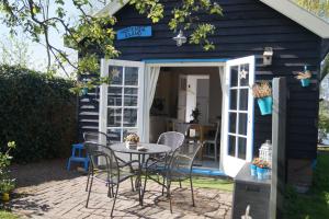 a patio with a table and chairs in front of a house at Hortensia Eiland in Zegveld