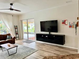 a living room with a flat screen tv on a wall at Sandy Oasis 5 bedroom with Pool Sarasota Bradenton in Bradenton