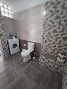 a bathroom with a toilet and a washing machine at kaite house in Kozani