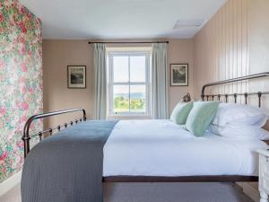 a bedroom with a large bed with a window at Stag Cottage in Penrith