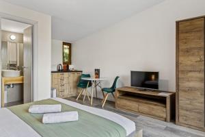 a bedroom with a bed and a desk and a television at Silver Bungalow in Săcele