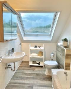 a bathroom with a skylight and a sink and a toilet at Wohntraeumerei Bergblick- Ihr privates Hideaway in Bad Berleburg, einem Wanderparadies in Bad Berleburg