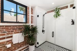a bathroom with a shower and a brick wall at The Brick Boutique Hotel in Oceanside