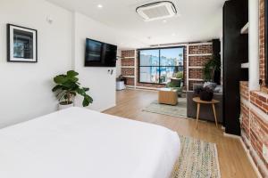 a bedroom with a white bed and a brick wall at The Brick Boutique Hotel in Oceanside