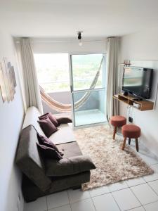 a living room with a couch and a television at Apartamento completo/ Verano Ponta Negra- Natal in Natal