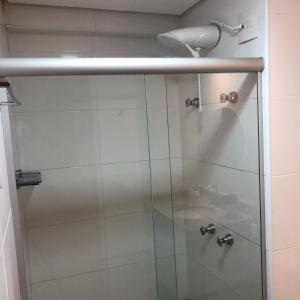 um chuveiro com uma porta de vidro na casa de banho em FlatsRose BR Executivo BrookField Flamboyant Conforto Top em Goiânia