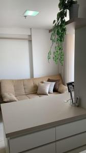 uma sala de estar com um sofá e um vaso de plantas em FlatsRose BR Executivo BrookField Flamboyant Conforto Top em Goiânia