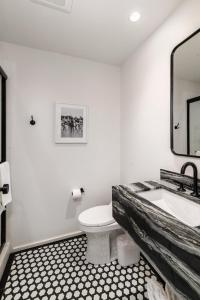 a bathroom with a sink and a toilet and a mirror at The Brick Boutique Hotel in Oceanside