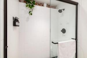 a shower with a glass door in a bathroom at The Brick Boutique Hotel in Oceanside